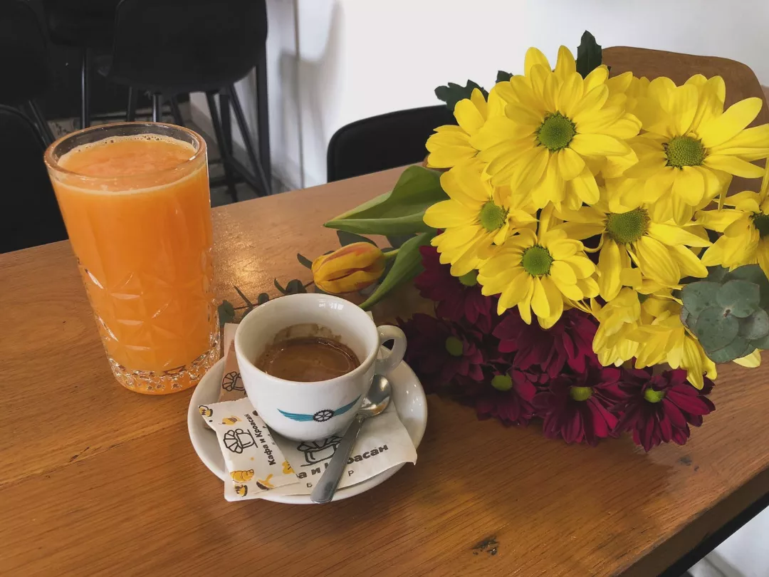 Kafa, sok i cveće na stolu